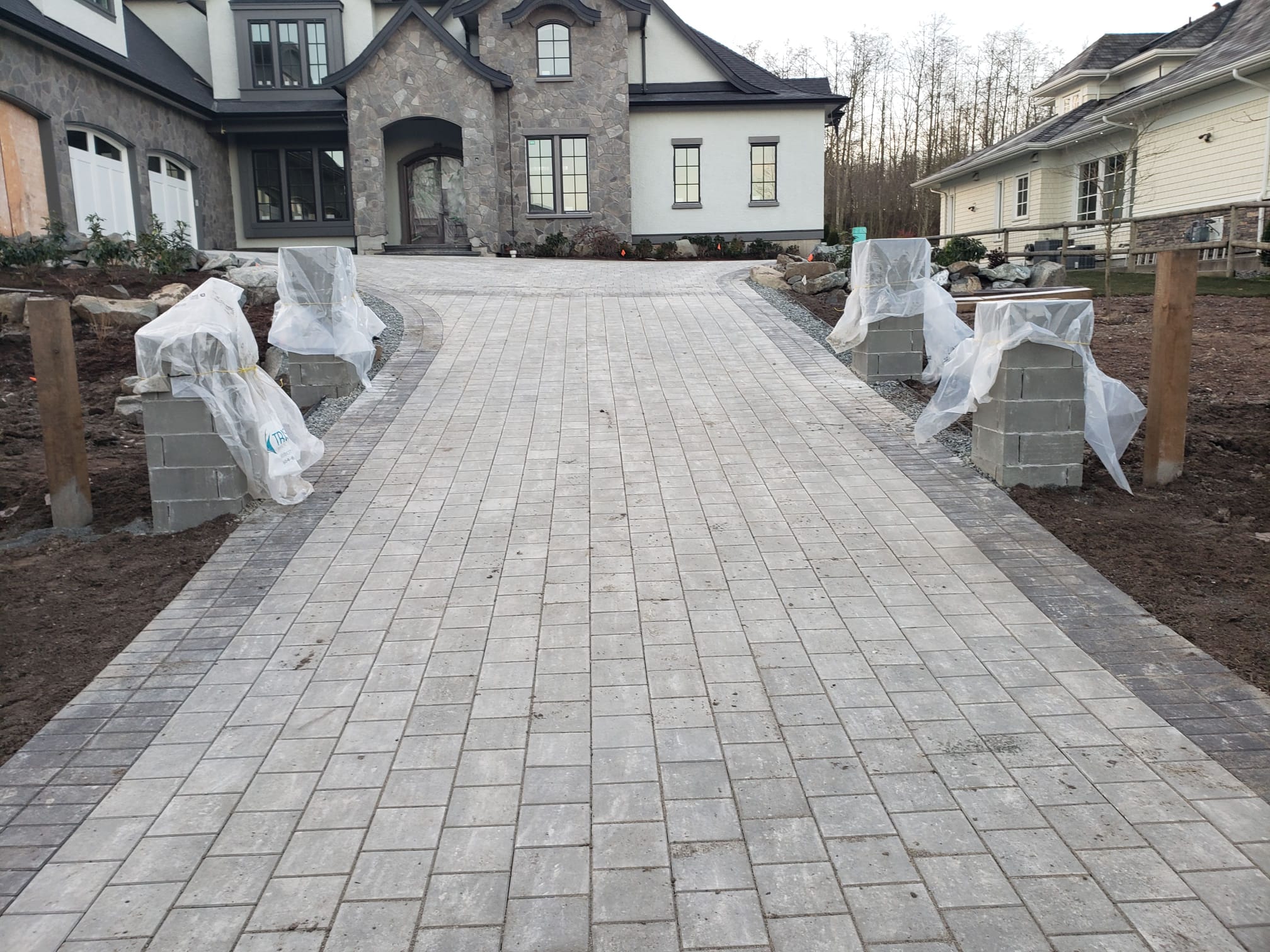 Large light-grey paver driveway installed by DKA Landscaping